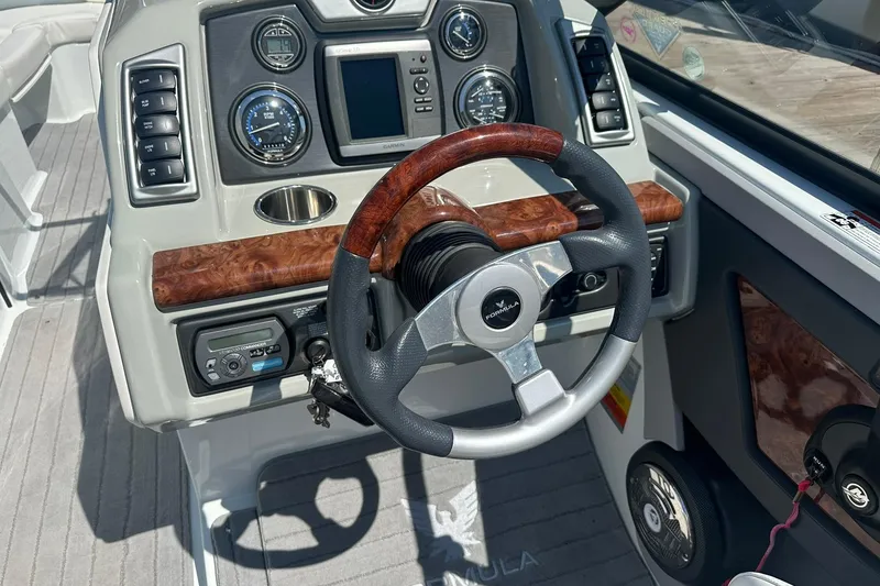 Slide: The Image of 2009 Formula 270 Bowrider dashboard with wood accents and modern controls. - 11