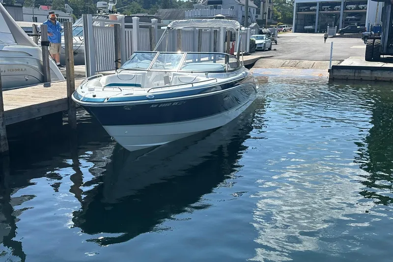 Slide: The Image of 2009 Formula 270 Bowrider boat docked at marina, reflecting on calm water. - 2