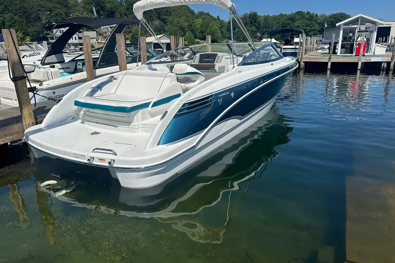 Slide: The Image of 2009 Formula 270 Bowrider boat docked in a marina, featuring sleek design and white-blue color scheme. - 4