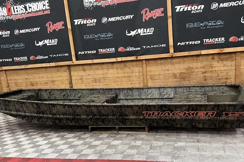 Slide: The Image of 2026 Tracker Grizzly® 15 Jon boat displayed indoors with branded backdrop. - 4