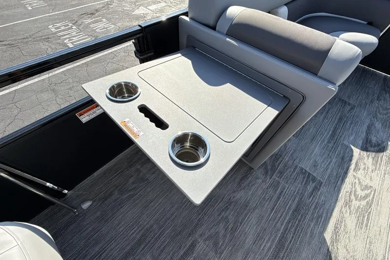 Slide: The Image of 2026 Landau Island Breeze 232 Sport Cruise boat interior with foldable table and cup holders. - 20