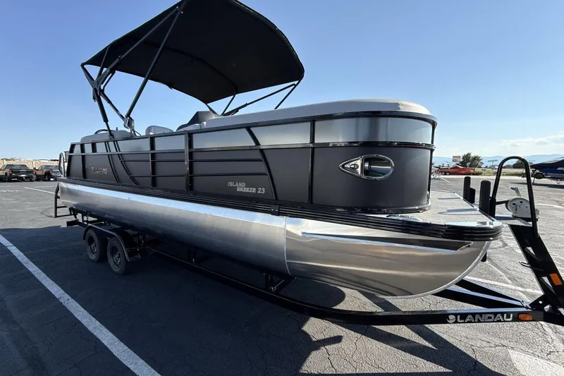 Slide: The Image of 2026 Landau Island Breeze 232 Sport Cruise pontoon boat on trailer, sunny day. - 7
