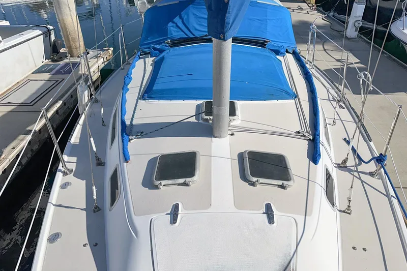 Slide: The Image of 1984 Catalina 30 sailboat deck with blue covers, docked at marina. - 25