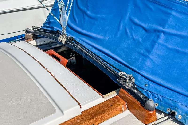 Slide: The Image of 1984 Catalina 30 sailboat with blue canvas cover and wooden trim details. - 26
