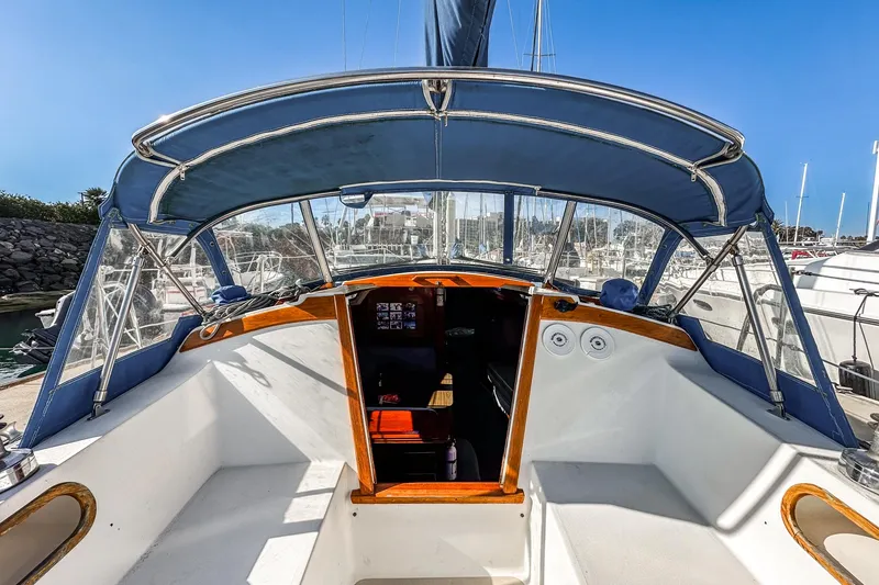 Slide: The Image of 1984 Catalina 30 sailboat cockpit with blue canopy, docked at marina. - 28