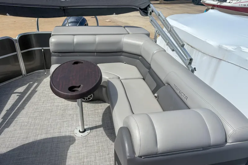Slide: The Image of 2021 Trifecta 22C CS 2.75 pontoon boat with gray seating and round table. - 5
