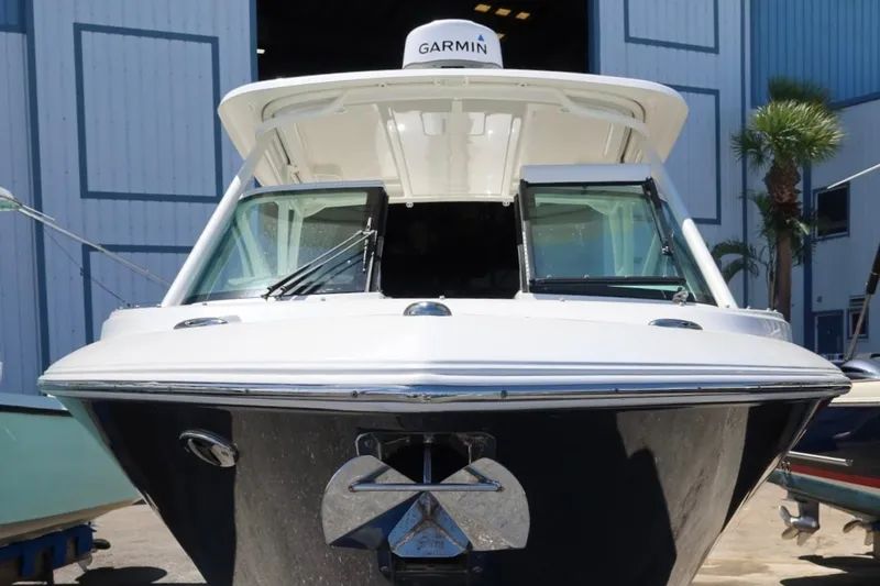 Slide: The Image of 2021 Pursuit DC 266 Dual Console boat with Garmin equipment, docked near a blue building. - 33