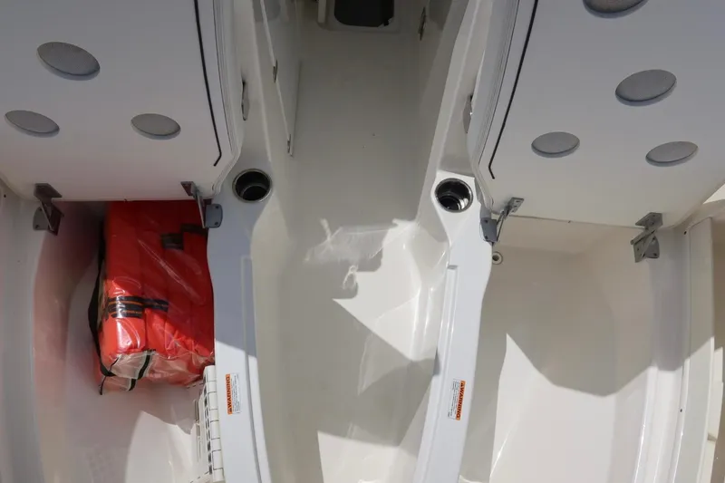 Slide: The Image of 2021 Pursuit DC 266 Dual Console boat interior with storage and life jacket. - 36