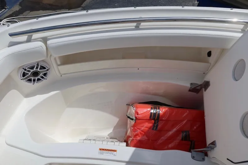 Slide: The Image of 2021 Pursuit DC 266 Dual Console boat storage with life jackets and speaker. - 38