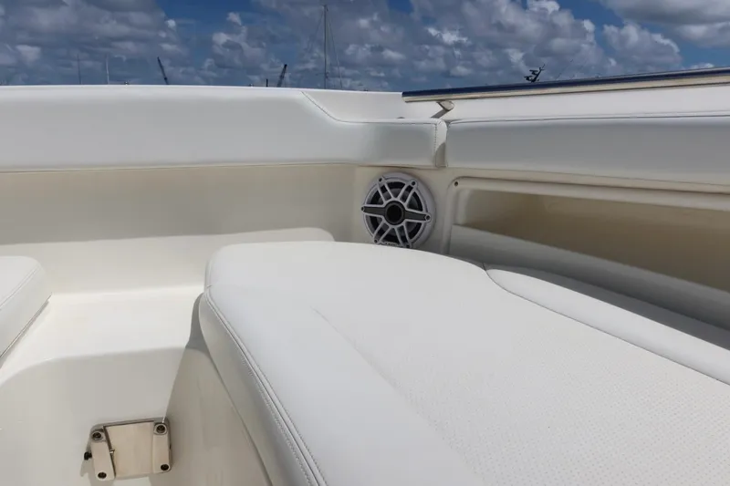 Slide: The Image of 2021 Pursuit DC 266 Dual Console boat interior with white seating and speaker. - 39