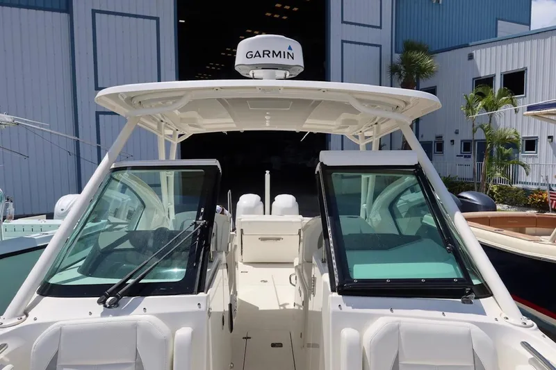 Slide: The Image of 2021 Pursuit DC 266 Dual Console boat with Garmin equipment, docked near a blue building. - 40