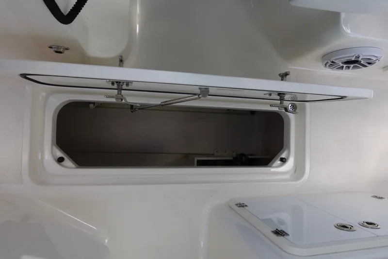 Slide: The Image of Open storage compartment on 2021 Pursuit DC 266 Dual Console boat interior. - 42