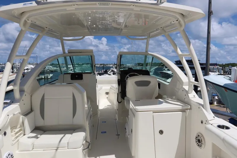 Slide: The Image of 2021 Pursuit DC 266 Dual Console boat interior with seating and helm, docked at marina. - 46