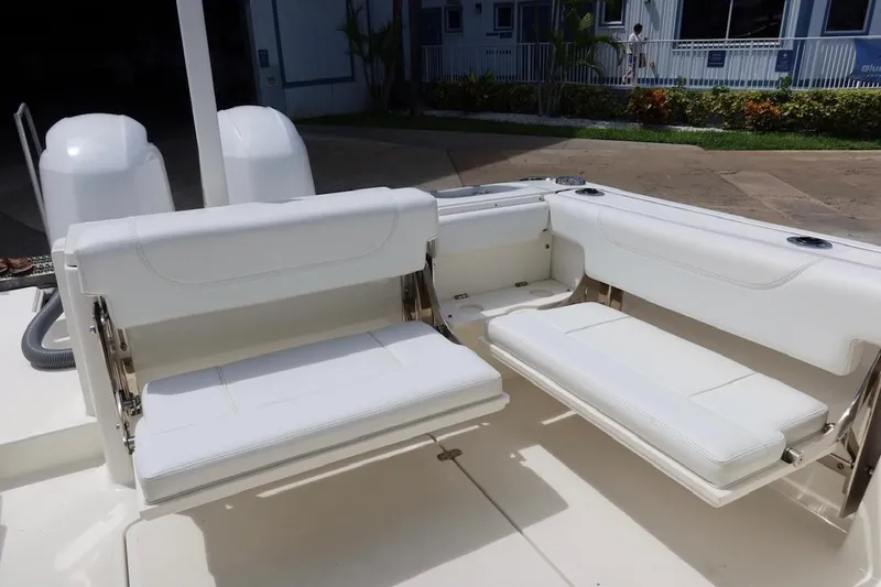 Slide: The Image of 2021 Pursuit DC 266 Dual Console boat with white cushioned seating and dual engines. - 49