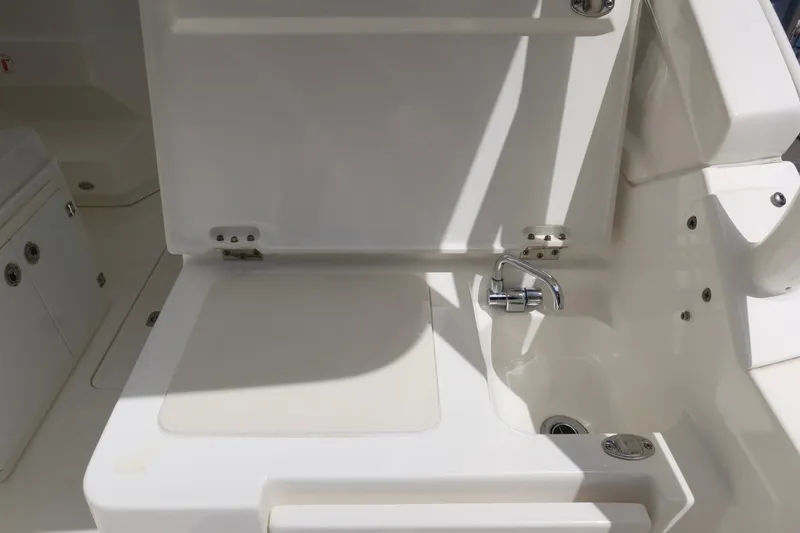 Slide: The Image of 2021 Pursuit DC 266 Dual Console boat interior with sink and storage area. - 50