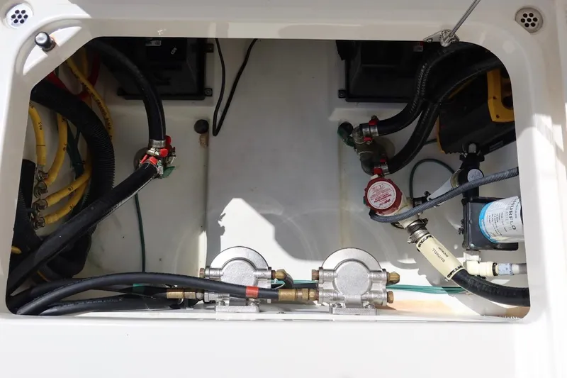 Slide: The Image of 2021 Pursuit DC 266 Dual Console engine compartment with hoses and mechanical components. - 56