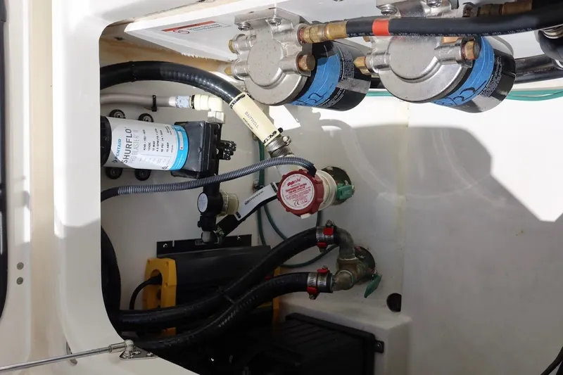 Slide: The Image of 2021 Pursuit DC 266 Dual Console boat engine compartment with Shurflo pump and filters. - 57