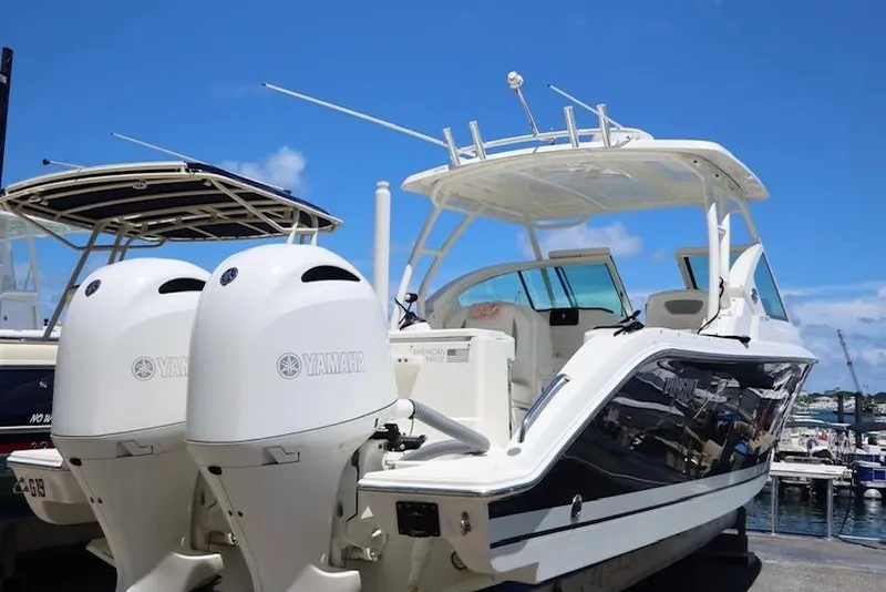 Slide: The Image of 2021 Pursuit DC 266 Dual Console boat with twin Yamaha engines at a marina. - 60