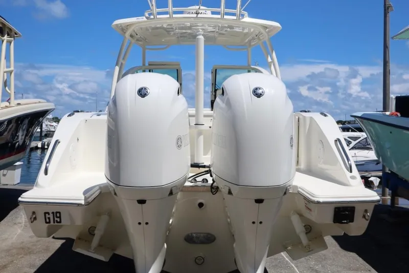Slide: The Image of 2021 Pursuit DC 266 Dual Console boat with twin outboard engines at a marina. - 61