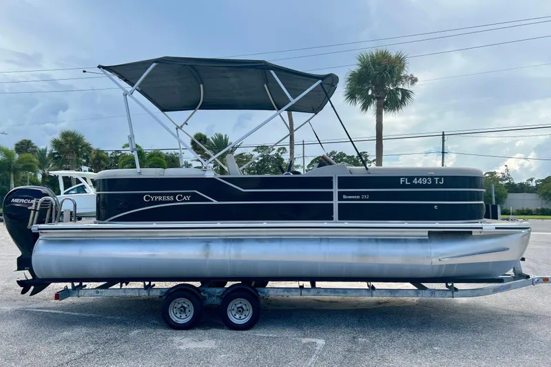 The Image of 2023 Cypress Cay Seabreeze 232 pontoon boat on trailer, parked outdoors. - 1