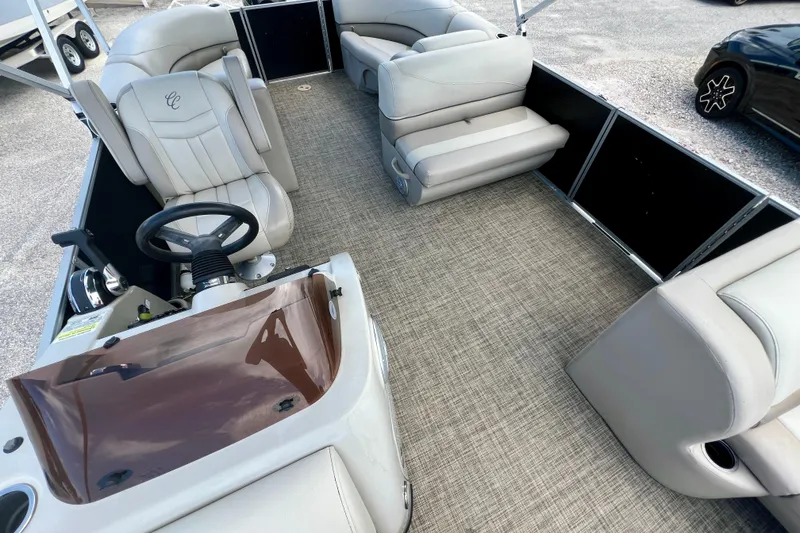 Slide: The Image of 2023 Cypress Cay Seabreeze 232 pontoon boat interior with plush seating and steering console. - 10