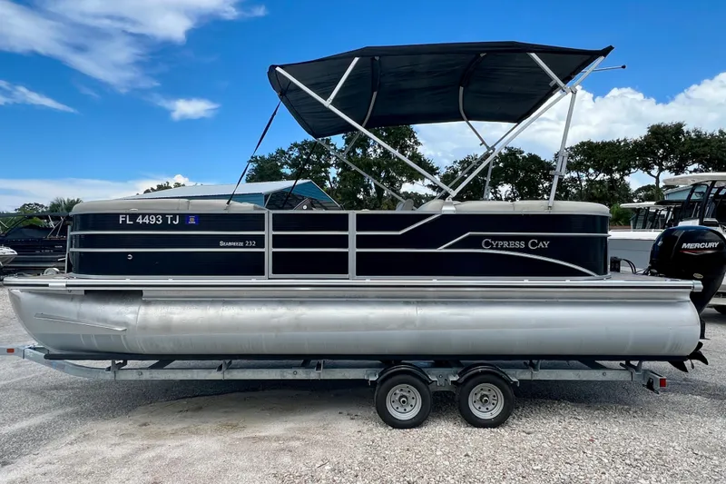 Slide: The Image of 2023 Cypress Cay Seabreeze 232 pontoon boat on trailer, under blue sky. - 5