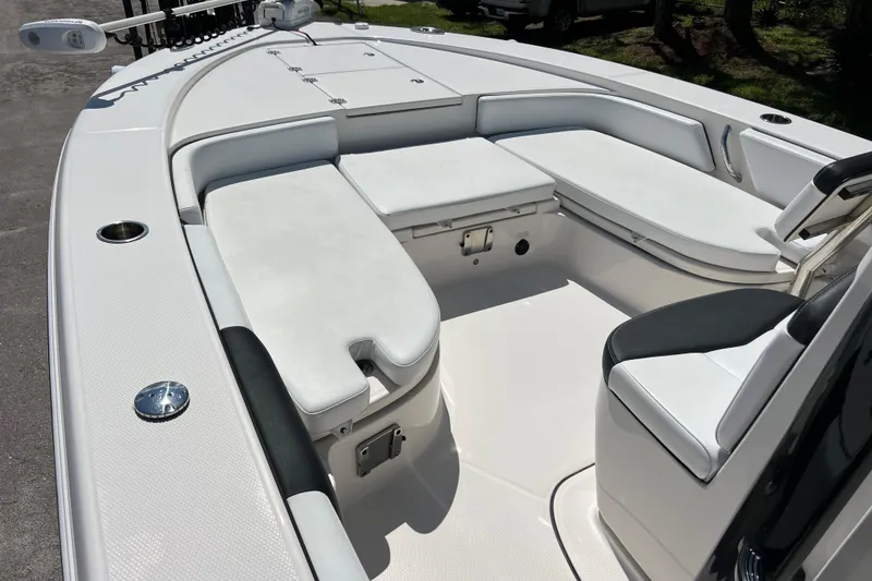 Slide: The Image of 2021 Robalo 246 Cayman SD boat interior with white cushioned seating and sleek design. - 11
