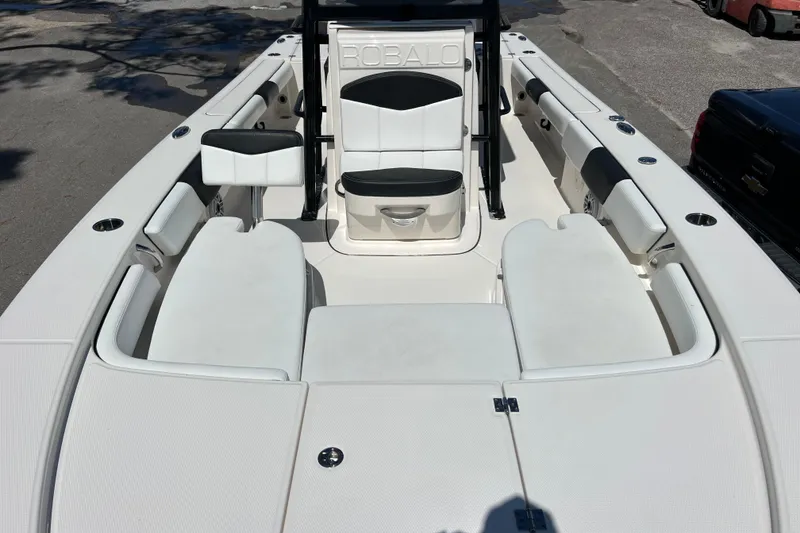 Slide: The Image of 2021 Robalo 246 Cayman SD boat interior with white seating and storage compartments. - 12