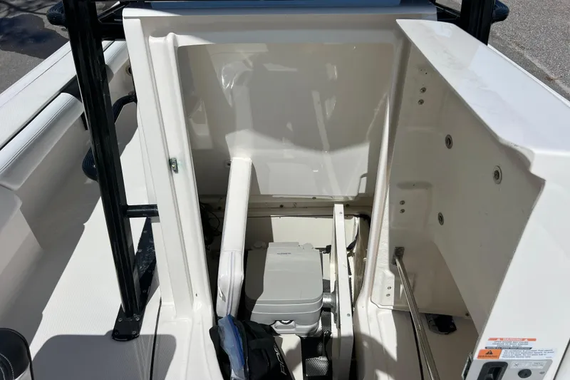 Slide: The Image of 2021 Robalo 246 Cayman SD boat interior storage compartment with portable toilet. - 13