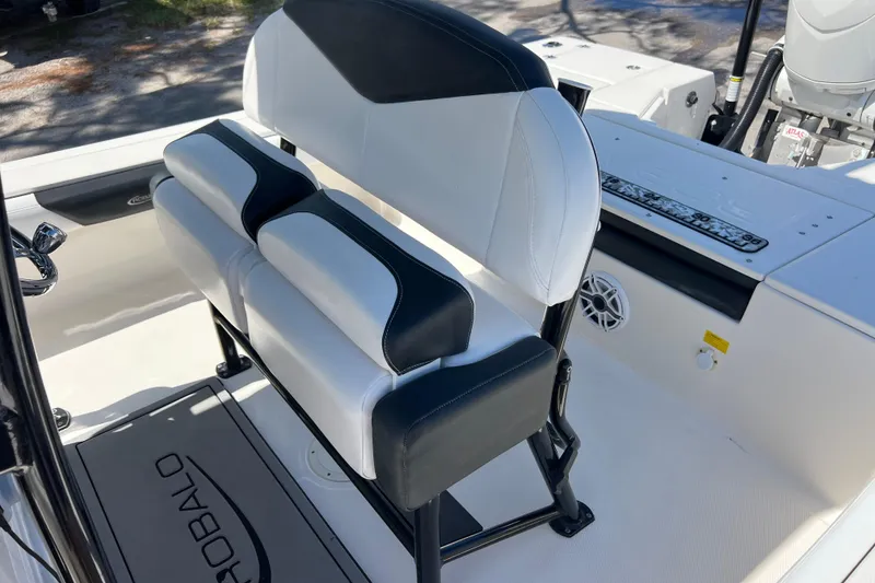 Slide: The Image of 2021 Robalo 246 Cayman SD boat interior with cushioned seating and control panel. - 14