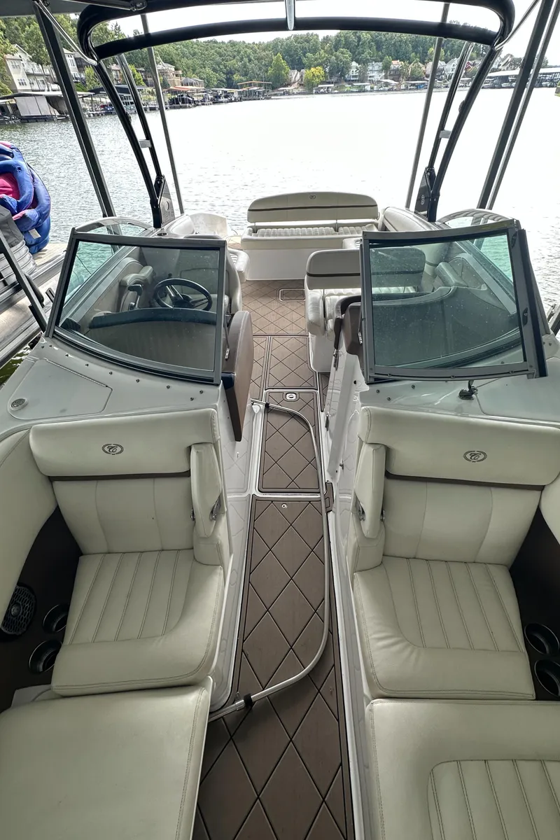 Slide: The Image of 2015 Cobalt R7 boat interior with white leather seats and open cockpit on a lake. - 13