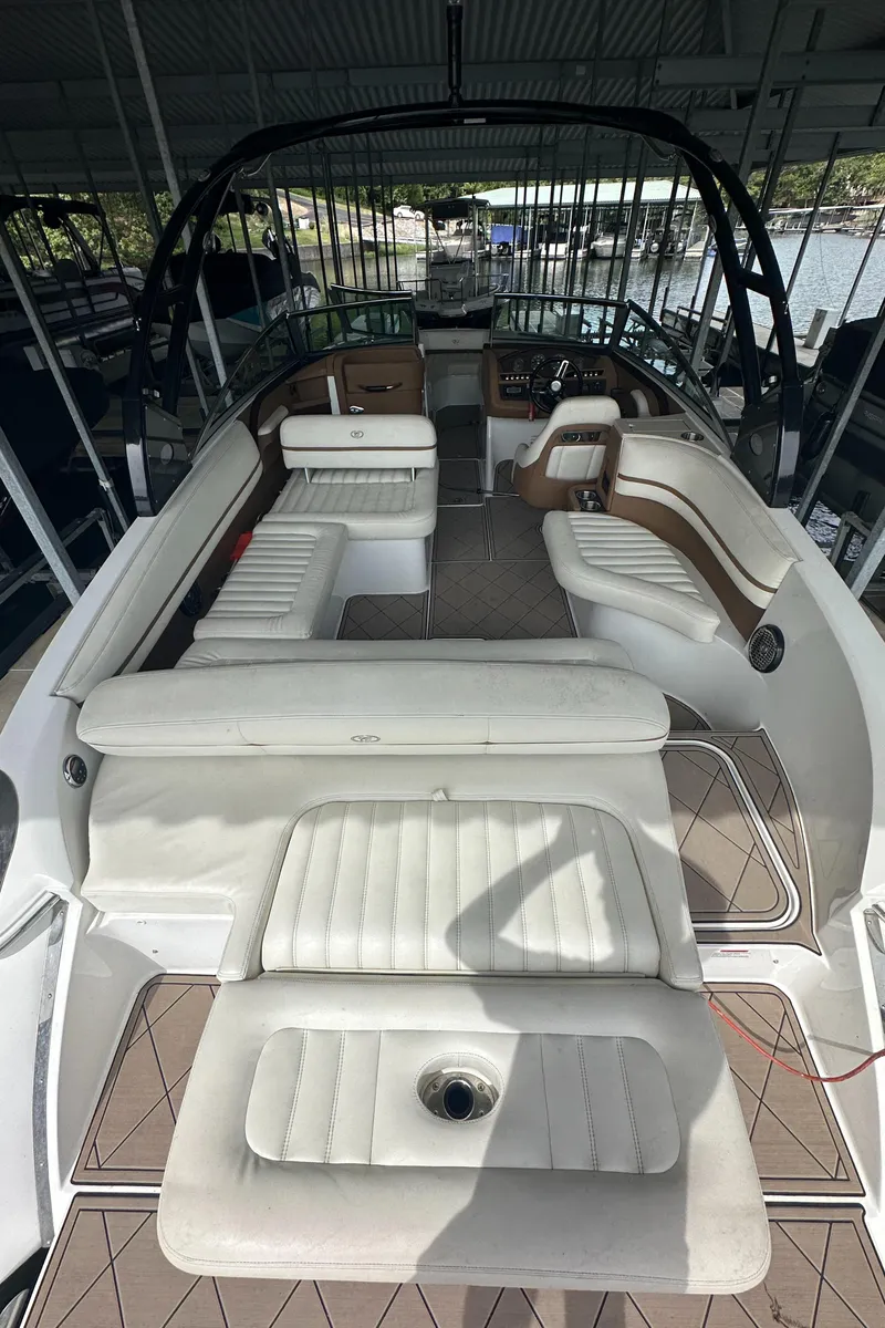 Slide: The Image of 2015 Cobalt R7 boat interior with white seating and sleek design under a covered dock. - 15