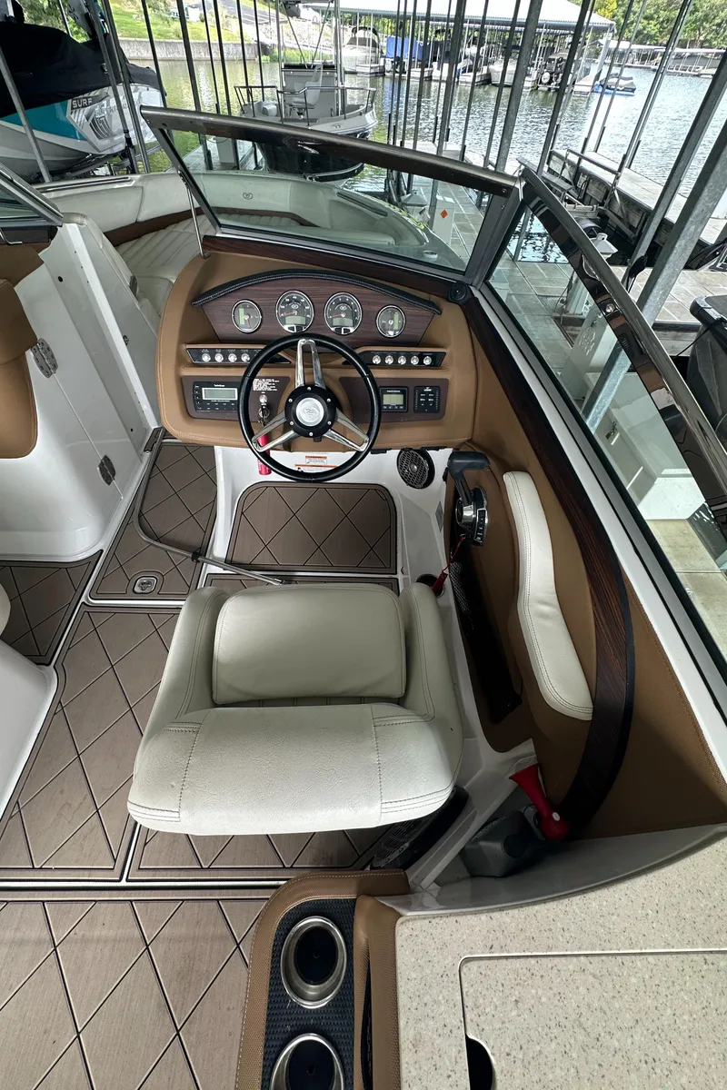 Slide: The Image of 2015 Cobalt R7 boat interior with steering wheel and dashboard, docked by the water. - 21