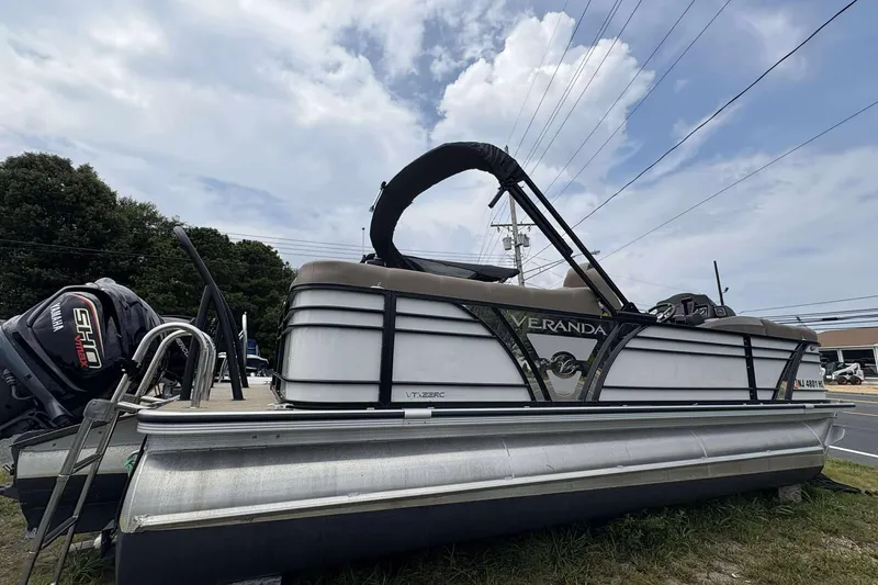Slide: The Image of 2023 Veranda VTX22RC pontoon boat with Yamaha engine, parked outdoors under a cloudy sky. - 25