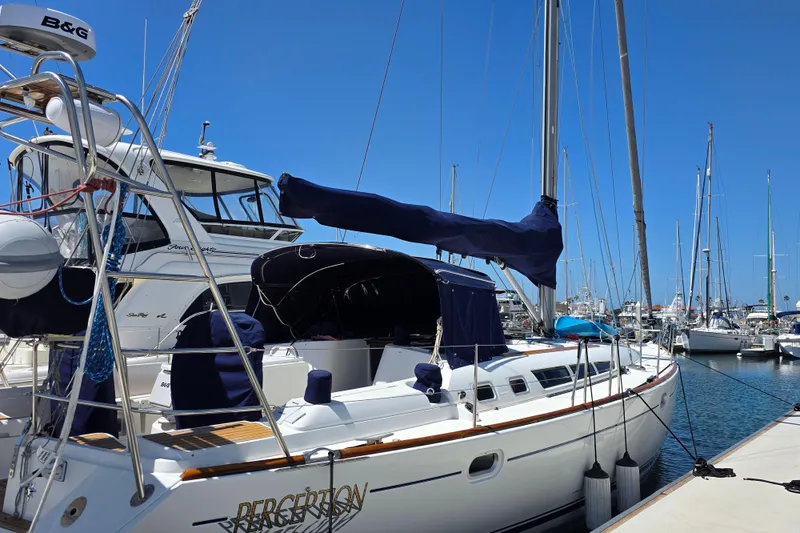Slide: The Image of 2007 Jeanneau 49 Performance sailboat docked at a marina under clear blue skies. - 12