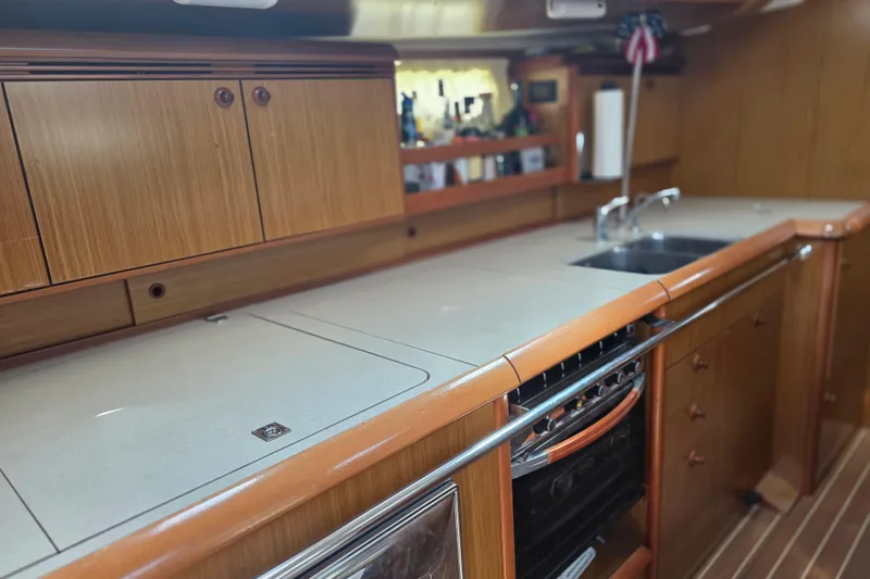 Slide: The Image of 2007 Jeanneau 49 Performance yacht kitchen with wooden cabinets and modern appliances. - 30