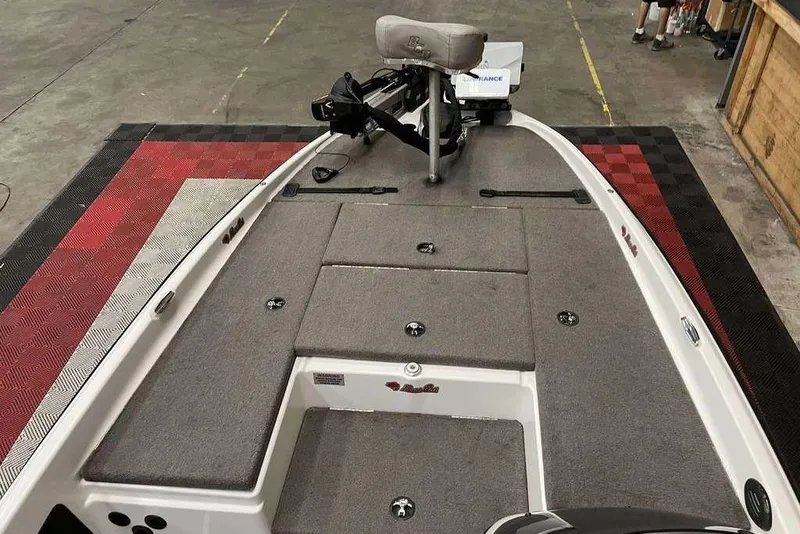 Slide: The Image of 2016 Bass Cat Pantera II boat interior with gray carpet and storage compartments. - 7