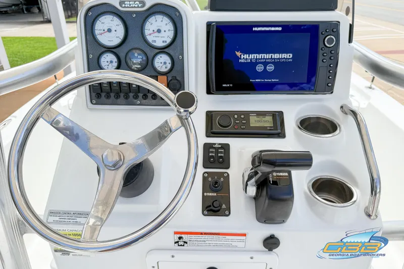 Slide: The Image of 2014 Sea Hunt BX 22 Pro boat dashboard with steering wheel, gauges, and Humminbird GPS system. - 15