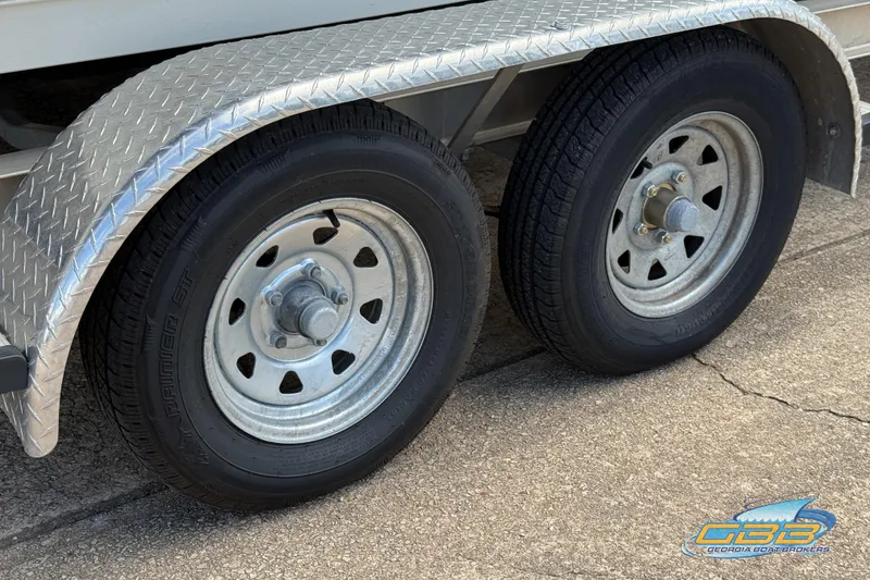 Slide: The Image of Trailer wheels of a 2014 Sea Hunt BX 22 Pro boat on pavement. - 29