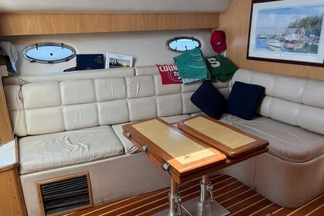 Slide: The Image of Interior of 2000 Tiara Yachts 4100 Open with white seating and wooden table. - 15