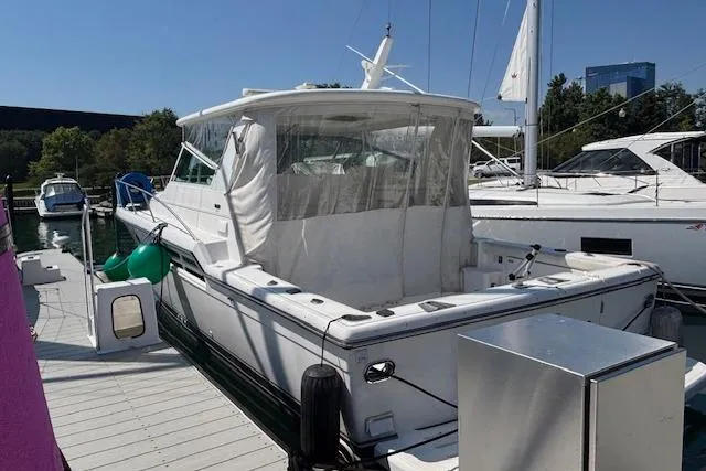 Slide: The Image of 2000 Tiara Yachts 4100 Open docked, featuring a spacious deck and clear canopy. - 19