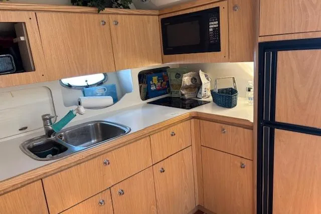 Slide: The Image of Interior of 2000 Tiara Yachts 4100 Open with cushioned seating and wooden table. - 2