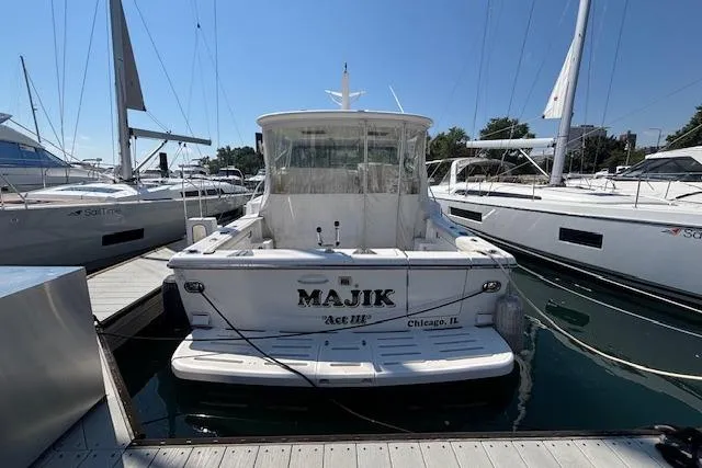 Slide: The Image of 2000 Tiara Yachts 4100 Open docked, rear view, with "MAJIK" name visible. - 20