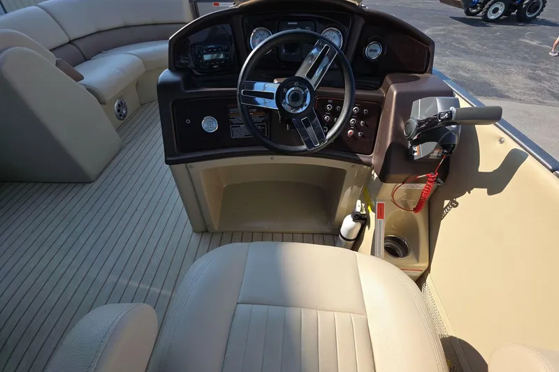 Slide: The Image of 2015 Crest III 230 SL boat interior with steering wheel and beige seating. - 10