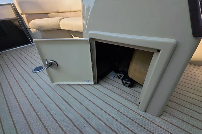 Slide: The Image of Open storage compartment on 2015 Crest III 230 SL boat with beige seating. - 12