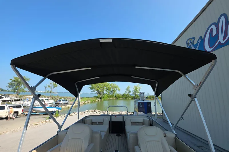 Slide: The Image of 2015 Crest III 230 SL pontoon boat with canopy, docked near a marina. - 14