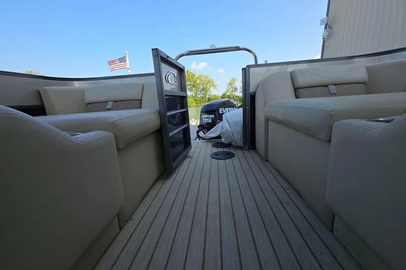 Slide: The Image of 2015 Crest III 230 SL boat interior with beige seating and Evinrude motor. - 16