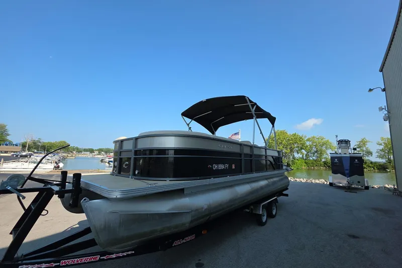 Slide: The Image of 2015 Crest III 230 SL pontoon boat on trailer near marina. - 3
