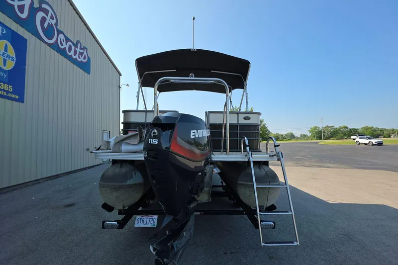 Slide: The Image of 2015 Crest III 230 SL pontoon boat with Evinrude motor, parked near a building. - 5