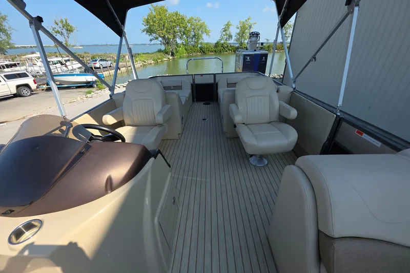 Slide: The Image of Interior of 2015 Crest III 230 SL pontoon boat with beige seating and steering console. - 8